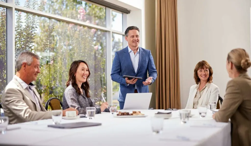 Corporate commercial photography showing a team of professionals engaging in a business meeting around a conference table.