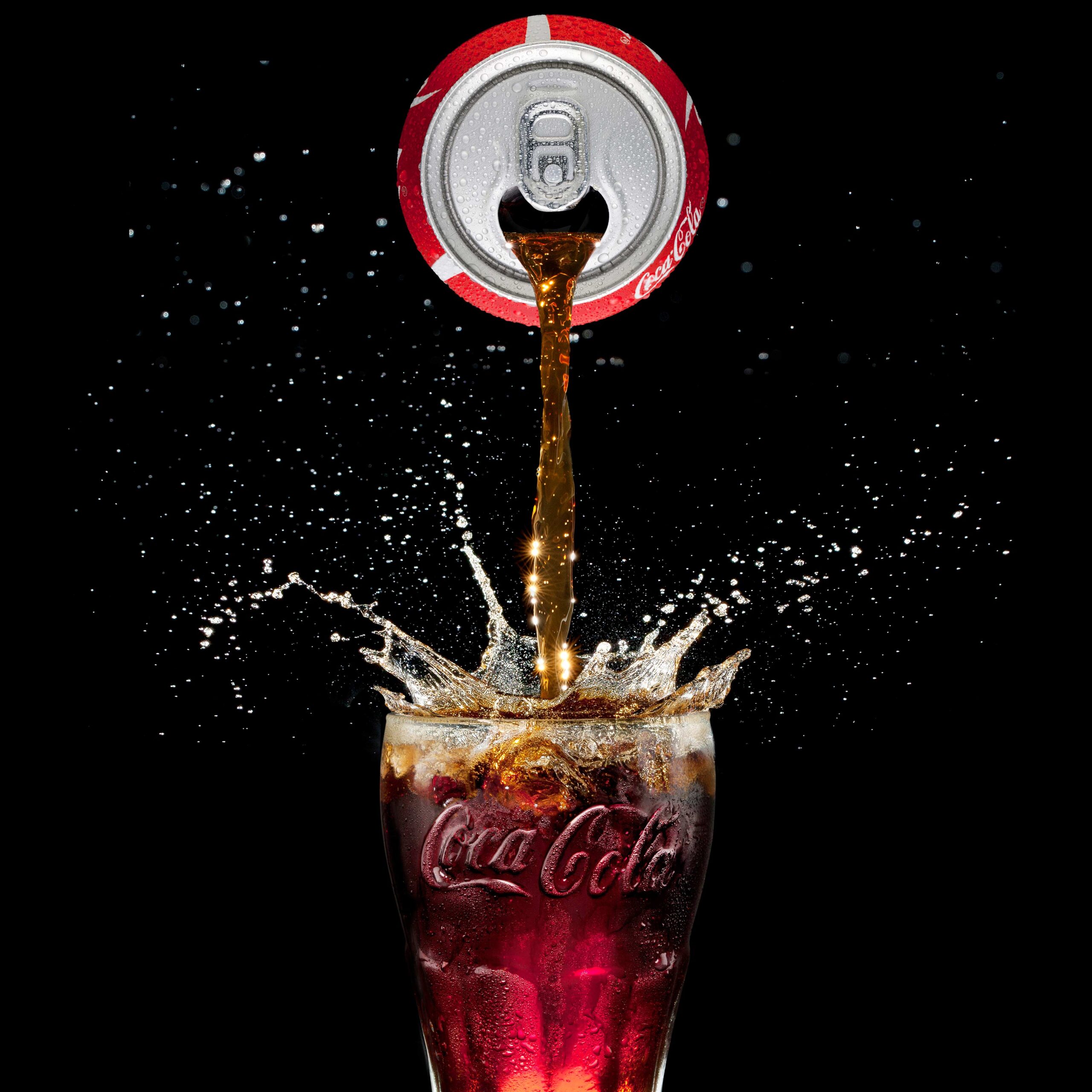 Product Photography of a Coca-Cola can be ported to a glass with epic splashes of water, making it look high-quality and luxury