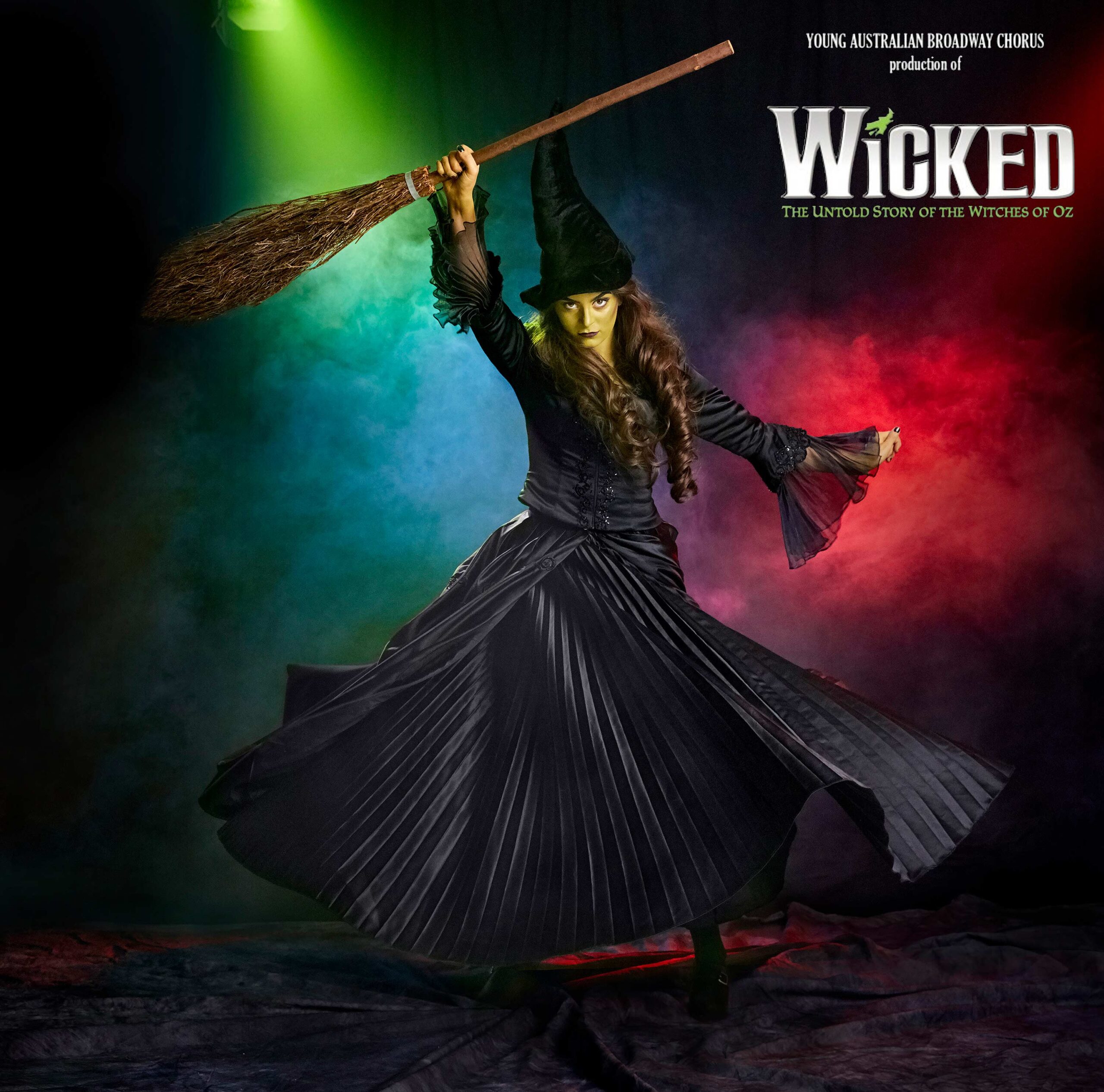 Advertising image for stage school, Australia's production show called wicked. Which holds up a broomstick on stage.
