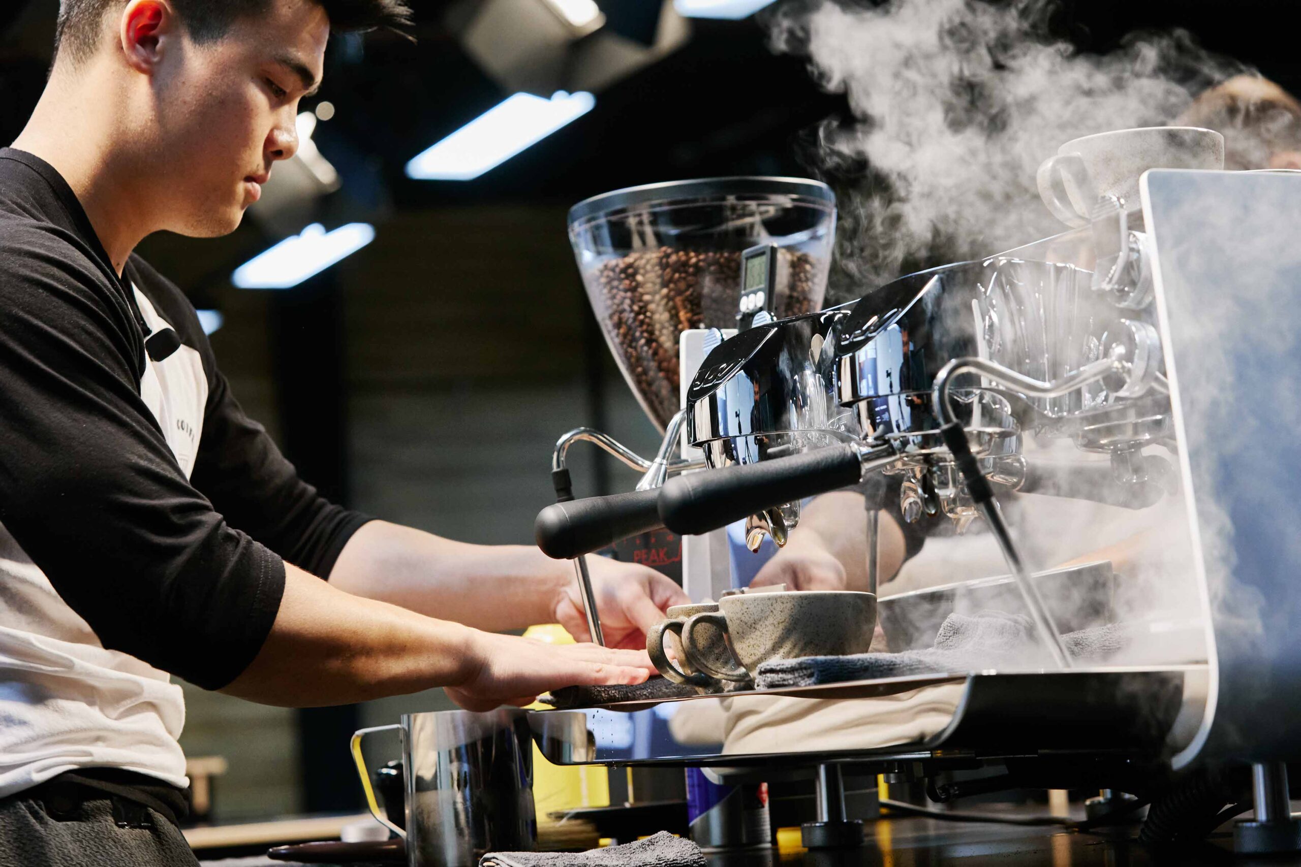 a barista brews uses a coffee machine
