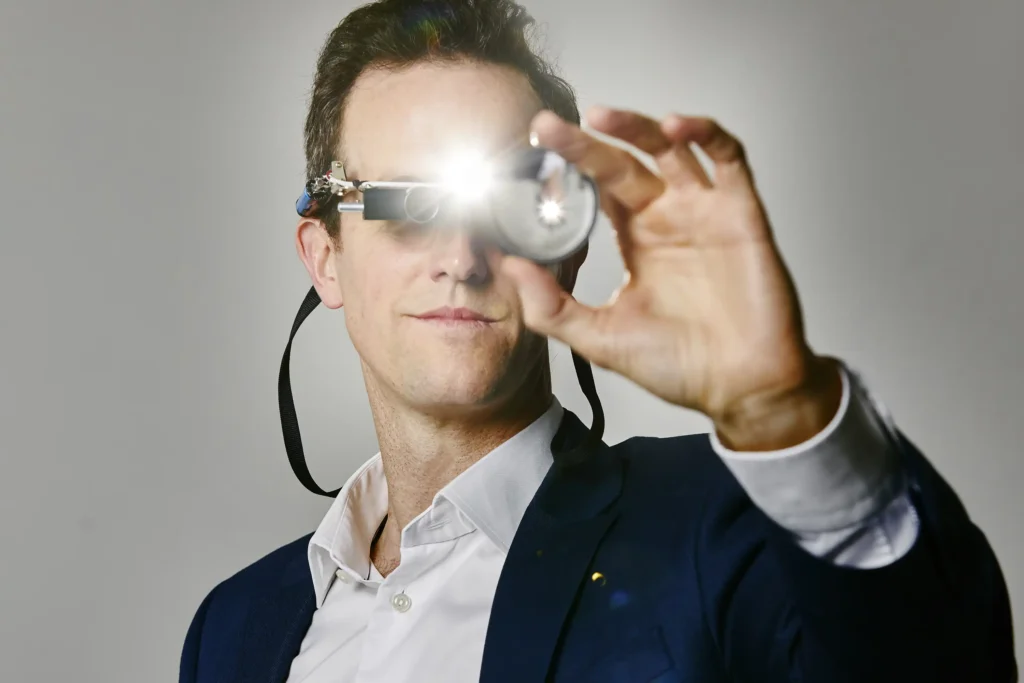 an Ophthalmologists portrait. man holding up a device