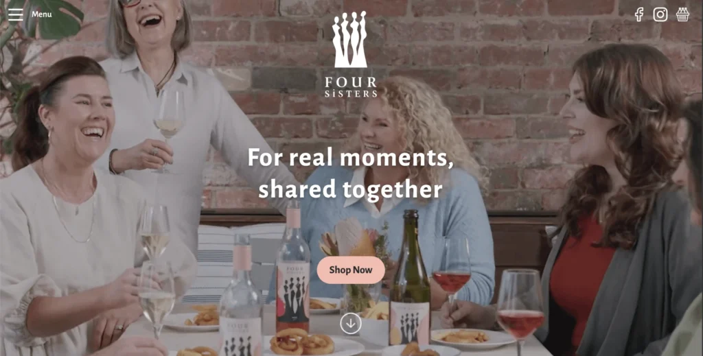 A horizontal website header banner crop showing a lively dinner party scene with friends and wine, created for the 4 Sisters website.